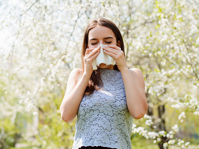 Woman stops to smell flowers outside of flower store