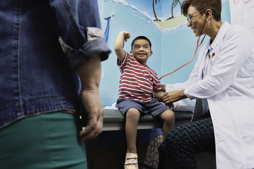 A pediatrician performs a routine exam on a child