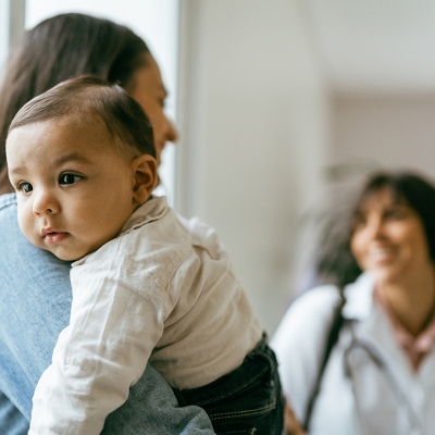 A mother with a new born on her shoulder