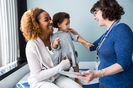 Una mujer y un niño sonriendo a un médico.