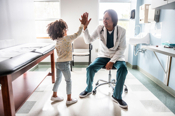 Un niño y un médico chocan los cinco en la consulta del médico